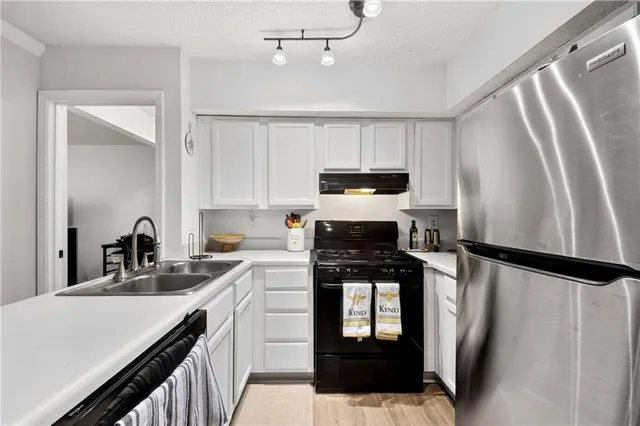 a kitchen with appliances a sink cabinets and a counter space