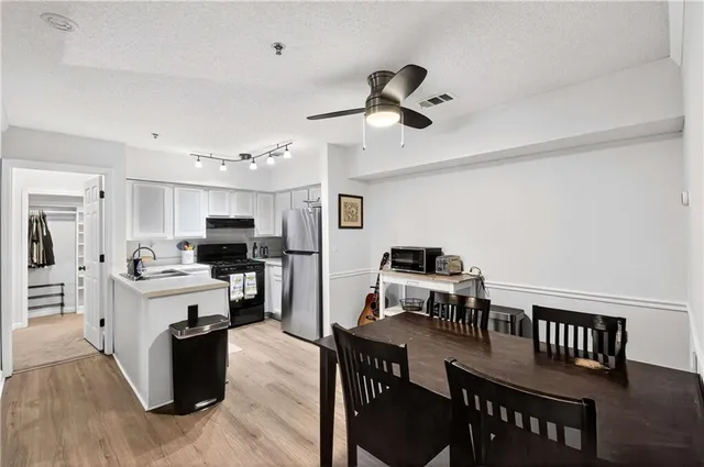 a view of a dining room with furniture a kitchen and chandelier