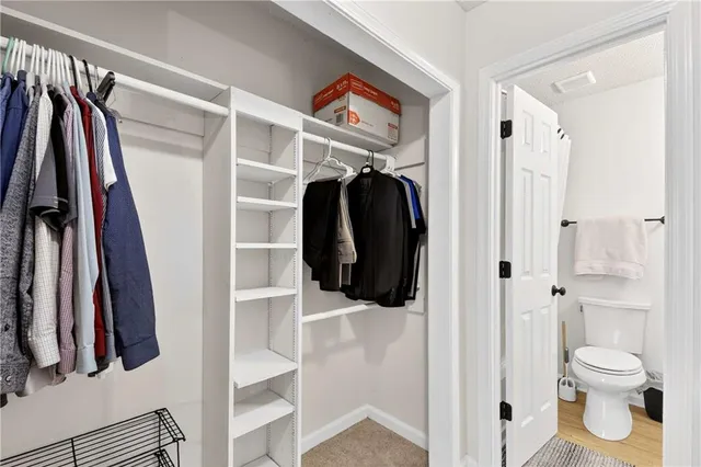 a view of walk in closet with clothes and shoes