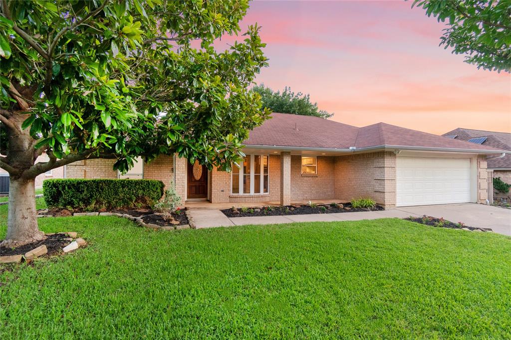 a front view of a house with a garden and trees
