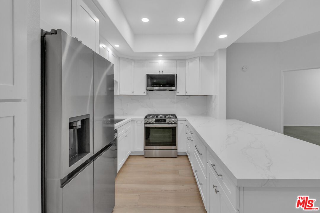 4477 Woodman Avenue, Unit 207 Sherman Oaks, CA 91423 - Photo 1 of 34 a kitchen with stainless steel appliances granite countertop a refrigerator and a stove