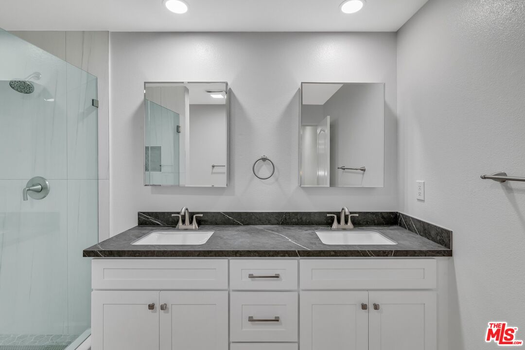 4477 Woodman Avenue, Unit 207 Sherman Oaks, CA 91423 - Photo 15 of 34 a bathroom with double sink and a mirror