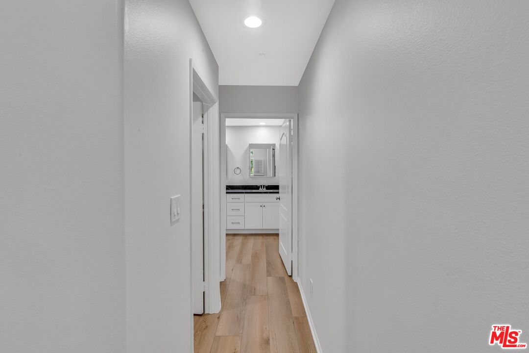 4477 Woodman Avenue, Unit 207 Sherman Oaks, CA 91423 - Photo 19 of 34 a view of a hallway with wooden floor and a kitchen