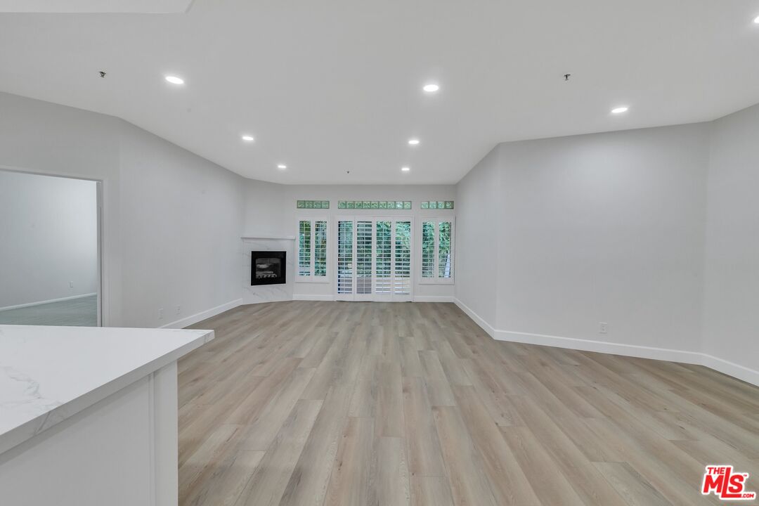 4477 Woodman Avenue, Unit 207 Sherman Oaks, CA 91423 - Photo 7 of 34 a view of an empty room with wooden floor and a window