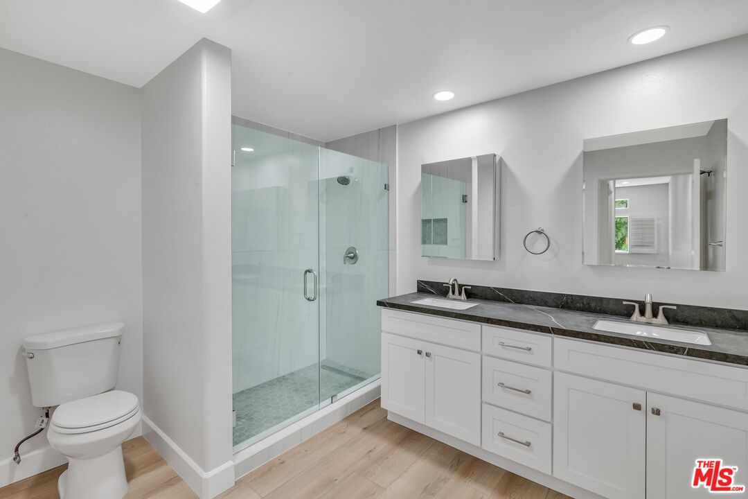 4477 Woodman Avenue, Unit 207 Sherman Oaks, CA 91423 - Photo 10 of 34 a bathroom with a granite countertop sink mirror and toilet