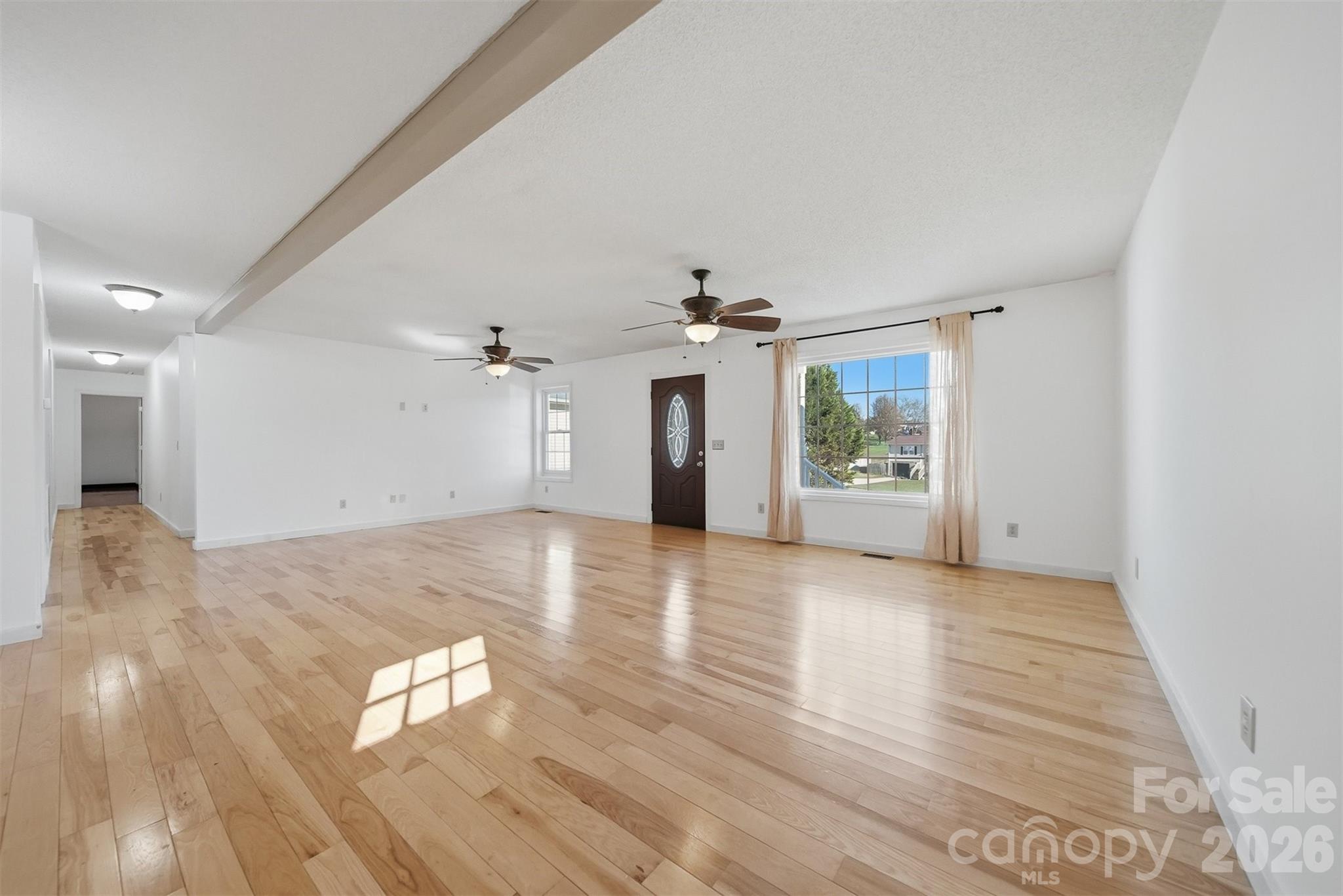 4771 Petra Mill Road Granite Falls, NC 28630 - Photo 18 of 46 an empty room with wooden floor chandelier and windows