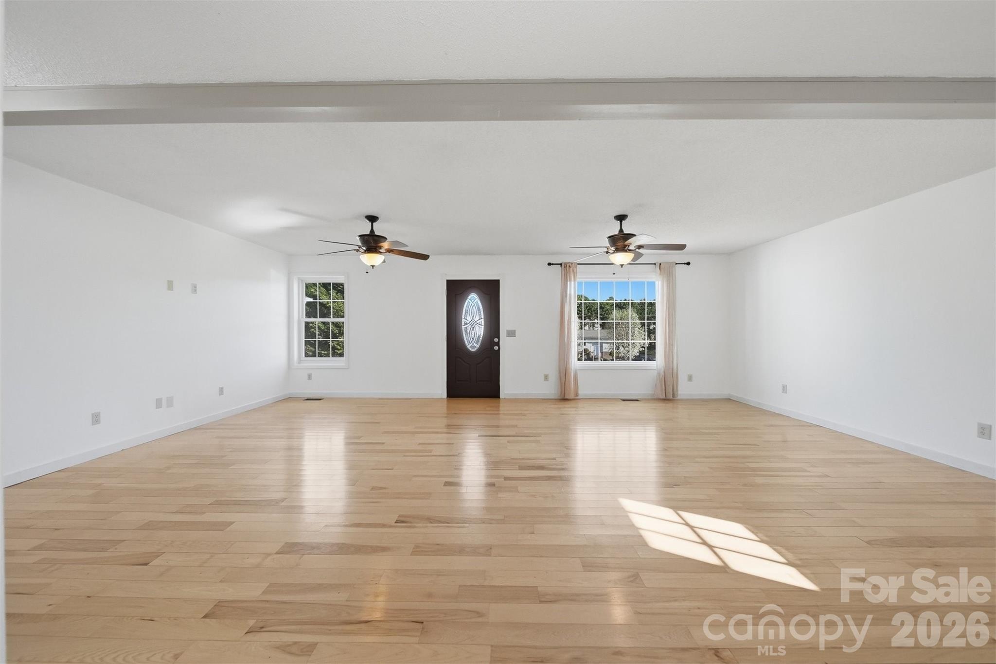 4771 Petra Mill Road Granite Falls, NC 28630 - Photo 22 of 46 a view of a livingroom with wooden floor and a ceiling fan