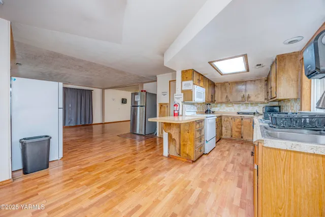 a view of a livingroom with wooden floor and furniture