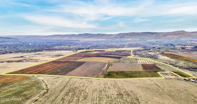 a kitchen with stainless steel appliances granite countertop a stove a sink dishwasher a refrigerator and white cabinets with wooden floor