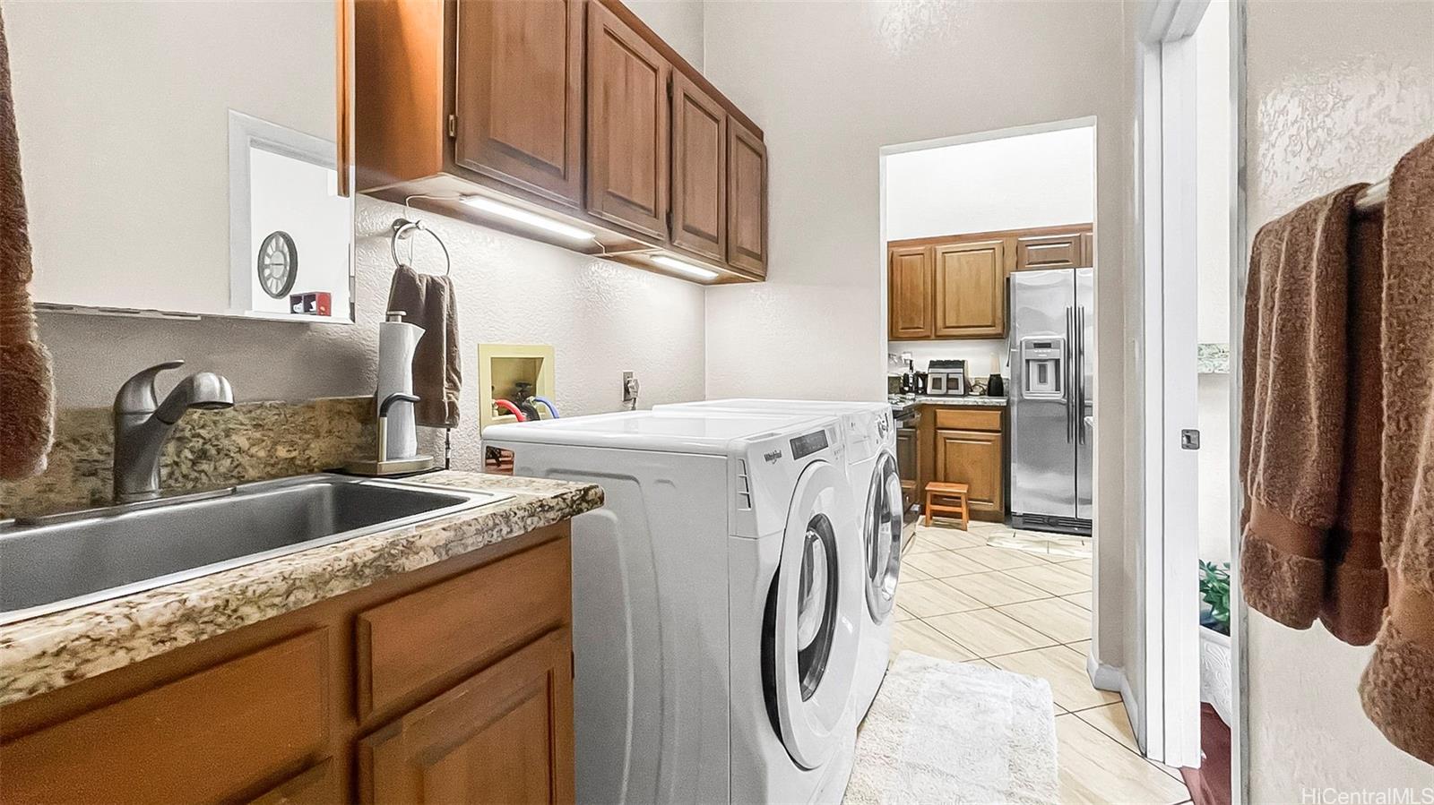 98-1421 Onikiniki Place, Unit 5 Aiea, HI 96701 - Photo 11 of 23 a kitchen with stainless steel appliances granite countertop a refrigerator a sink a stove and cabinets