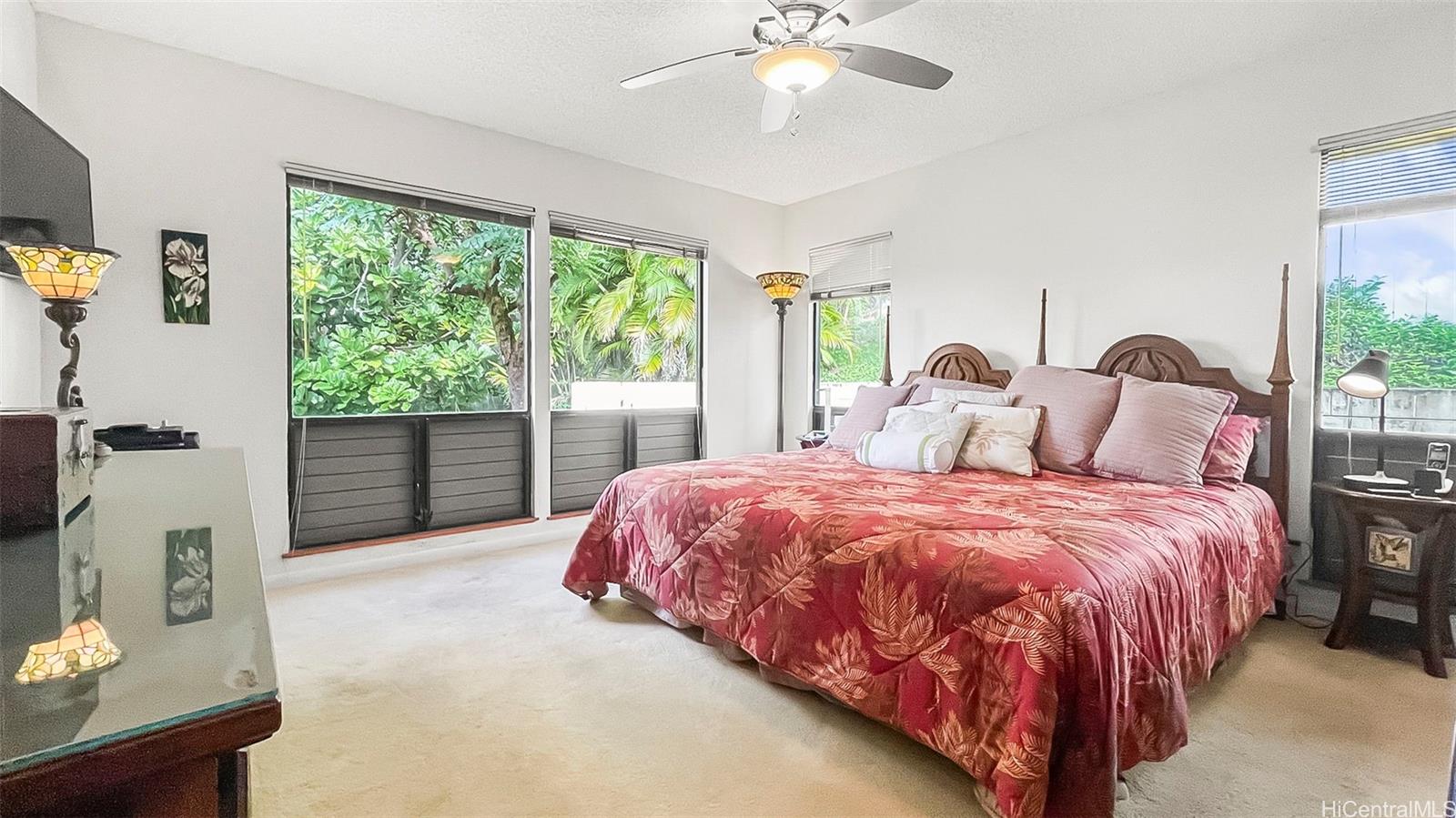 98-1421 Onikiniki Place, Unit 5 Aiea, HI 96701 - Photo 12 of 23 a bed sitting in a spacious bedroom next to a window