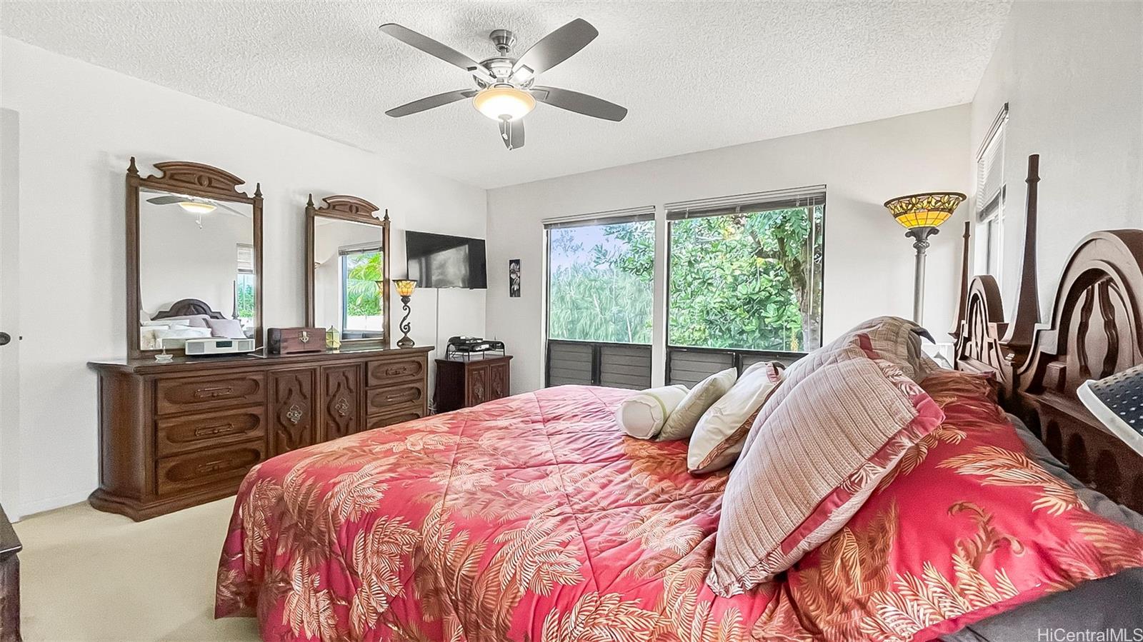 98-1421 Onikiniki Place, Unit 5 Aiea, HI 96701 - Photo 13 of 23 a bed sitting in a bedroom next to a window