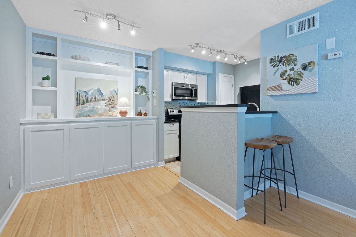 a kitchen with a refrigerator and a wooden cabinets