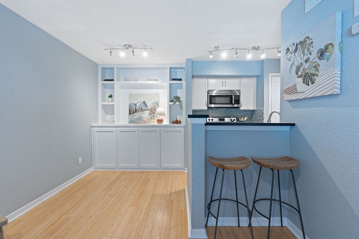 3204 Menchaca Road, Unit 303 Austin, TX 78704 - Photo 13 of 26 a living room with a fireplace and a chandelier