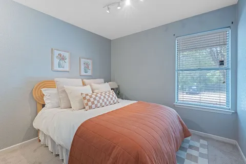 a bed sitting in a bedroom next to a window