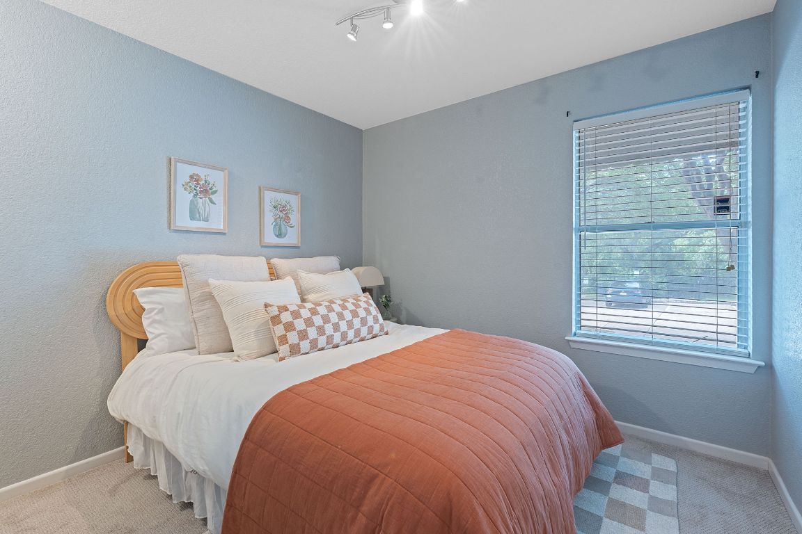 3204 Menchaca Road, Unit 303 Austin, TX 78704 - Photo 4 of 26 a bed sitting in a bedroom next to a window
