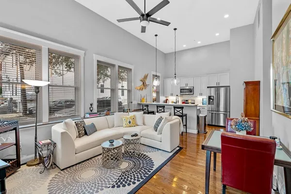a living room with fireplace furniture and a large window