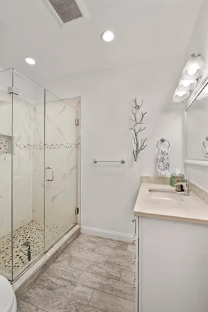 a bathroom with a sink shower and a mirror