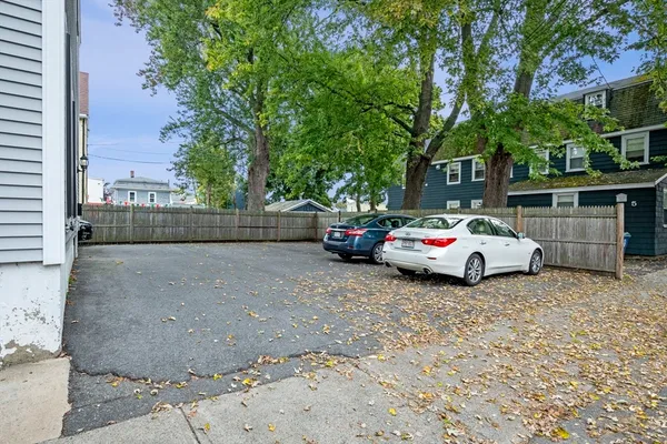 a white house that has a tree on the side of it