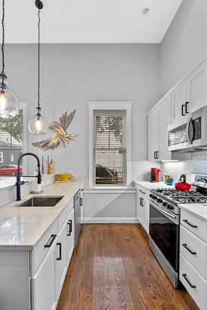 a kitchen that has a lot of cabinets in it and wooden floors