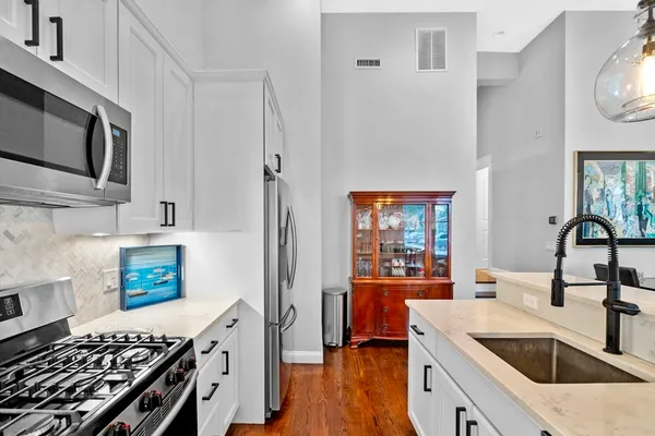 a kitchen with stainless steel appliances a stove a sink and a microwave