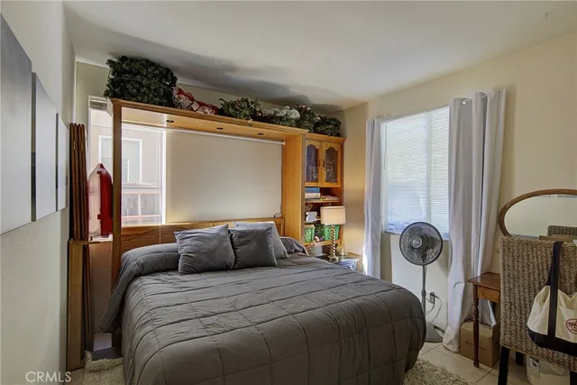 a bedroom with a bed a mirror and a window