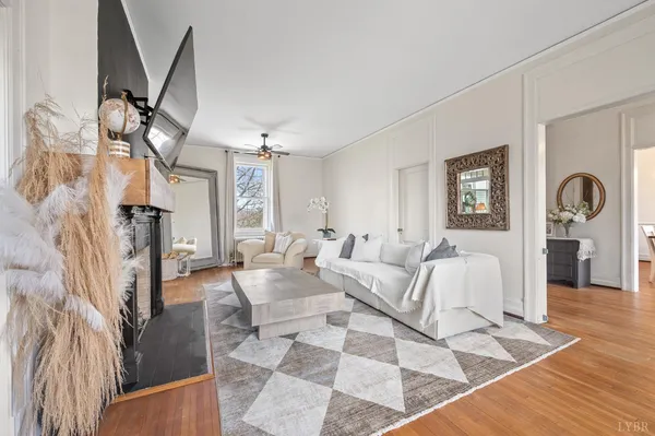 a living room with furniture a fireplace and a chandelier
