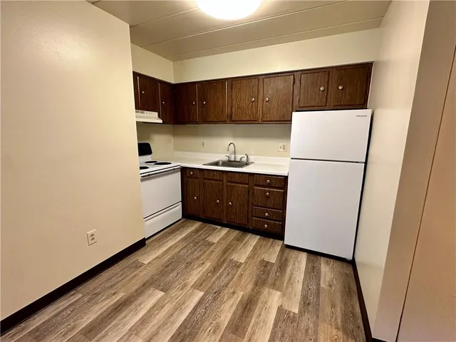 a kitchen with sink a refrigerator and cabinets