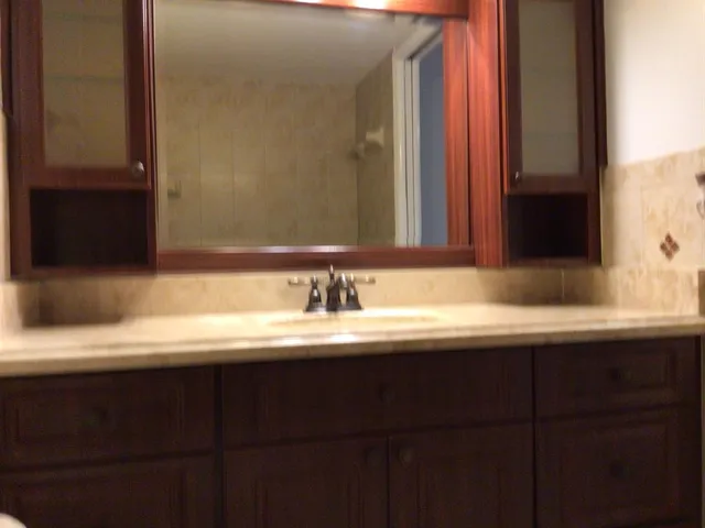 a bathroom with a granite countertop sink and a mirror