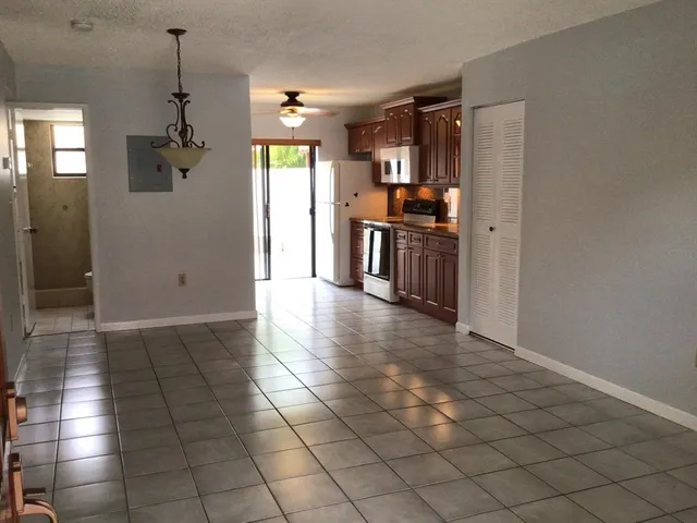 a view of a hallway with windows and chandelier