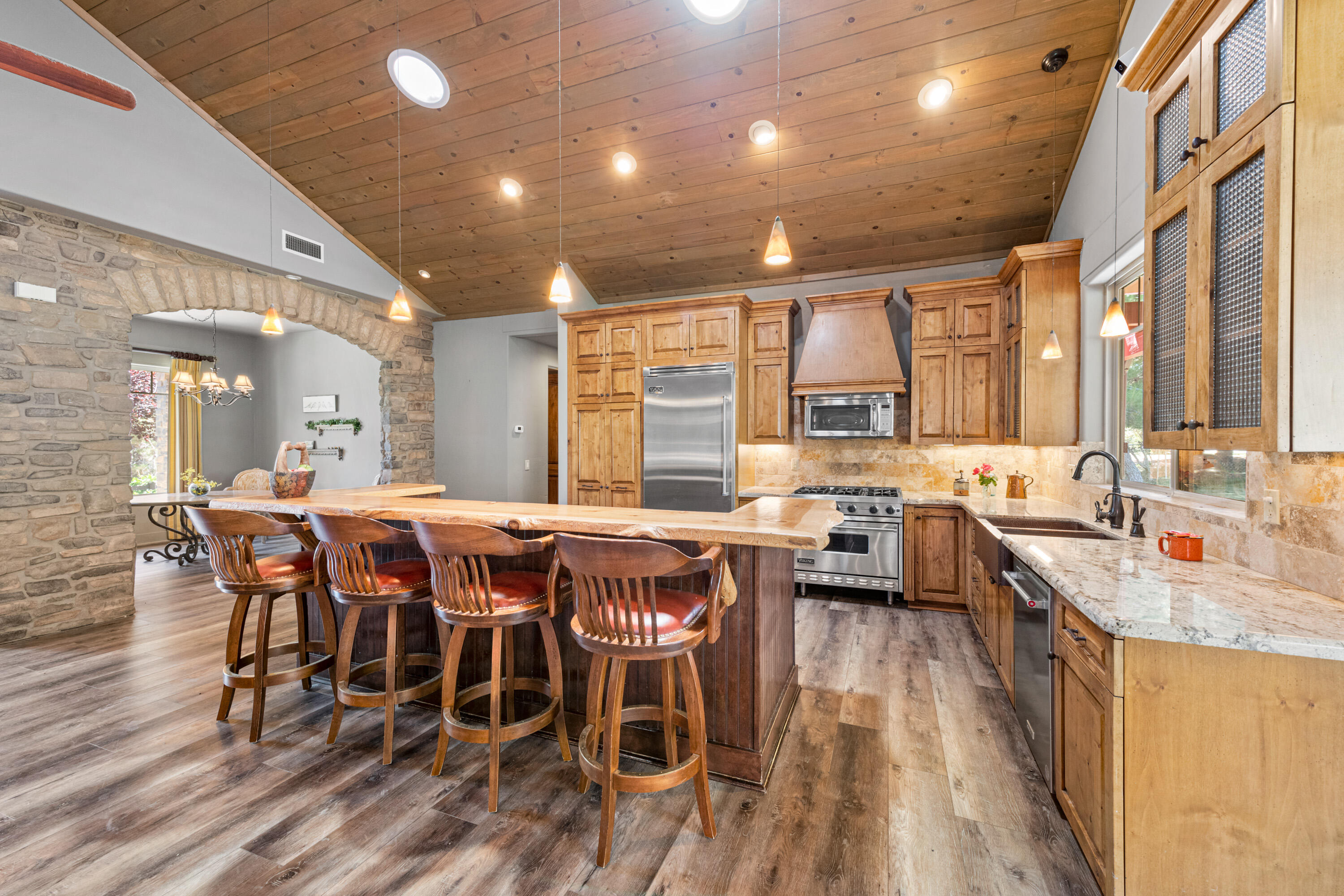 59985 Hop Patch Spring Road Mountain Center, CA 92561 - Photo 12 of 63 a dining hall with stainless steel appliances granite countertop a stove a sink dishwasher a dining table and chairs with wooden floor