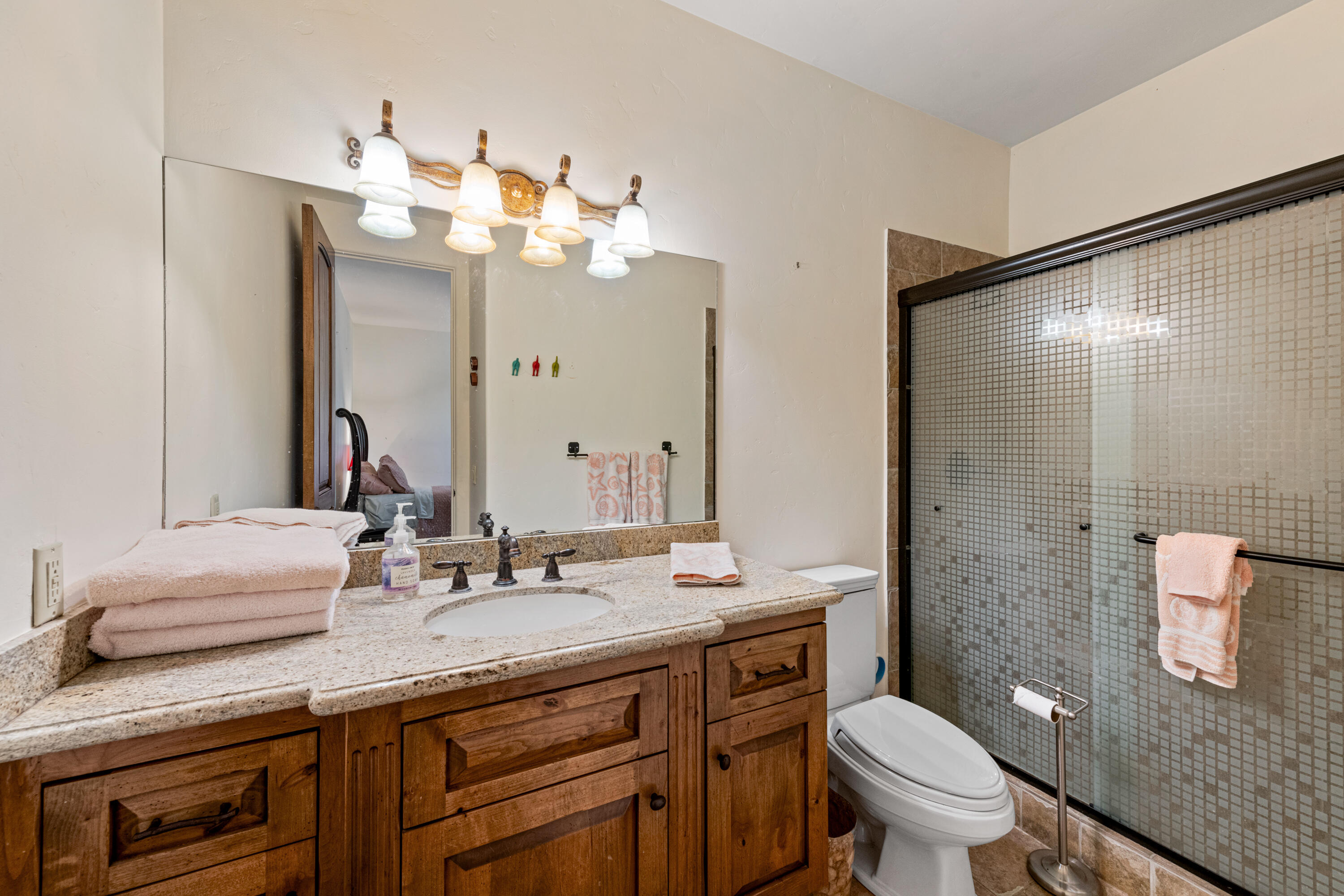 59985 Hop Patch Spring Road Mountain Center, CA 92561 - Photo 35 of 63 a bathroom with a granite countertop sink a toilet and a mirror