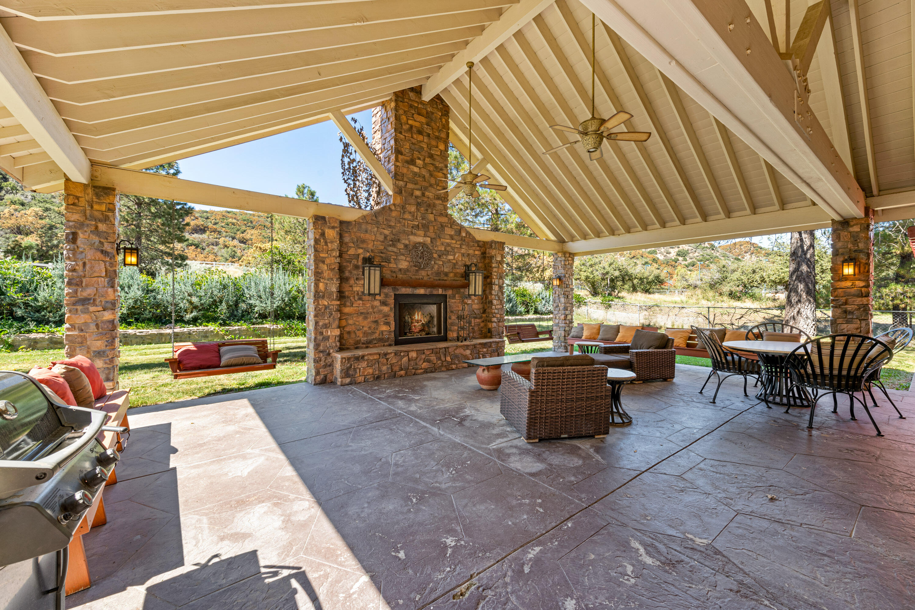 59985 Hop Patch Spring Road Mountain Center, CA 92561 - Photo 36 of 63 a view of a patio with couches and chairs under an umbrella