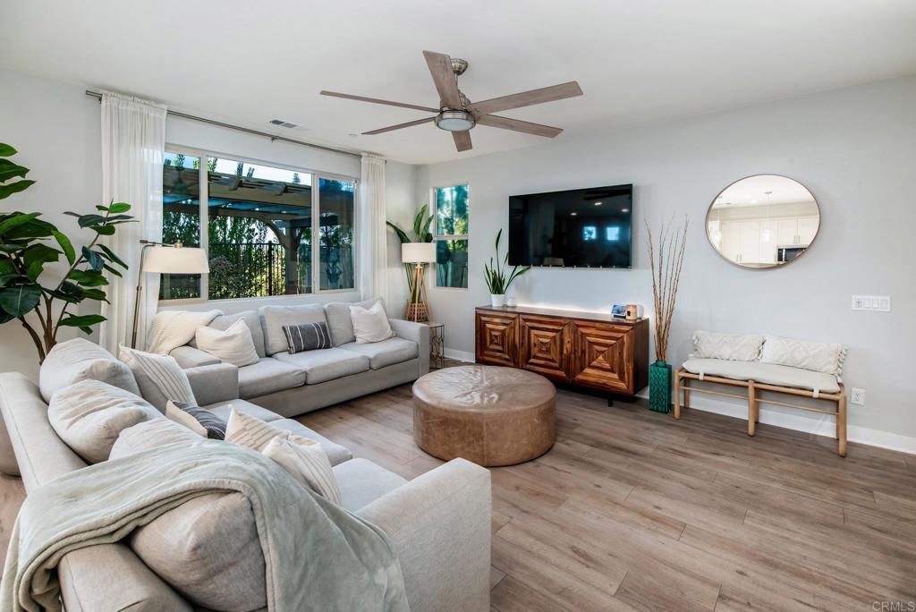 1244 Via Candelas Oceanside, CA 92056 - Photo 23 of 60 a living room with furniture a flat screen tv and a floor to ceiling window