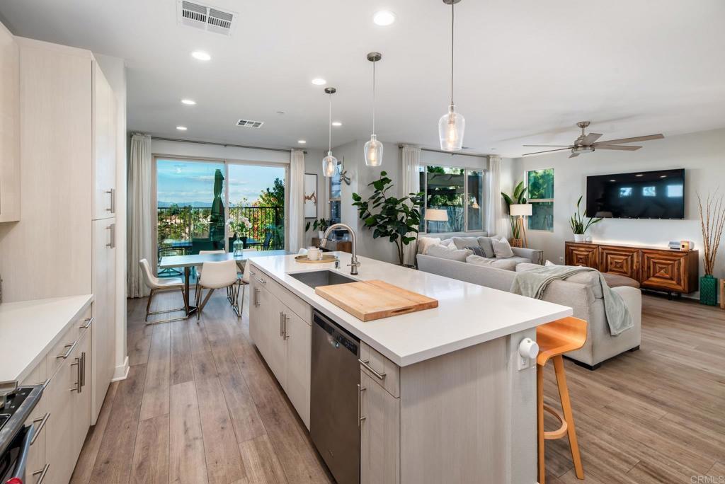 1244 Via Candelas Oceanside, CA 92056 - Photo 32 of 60 a large kitchen with sink a counter top space and living room view