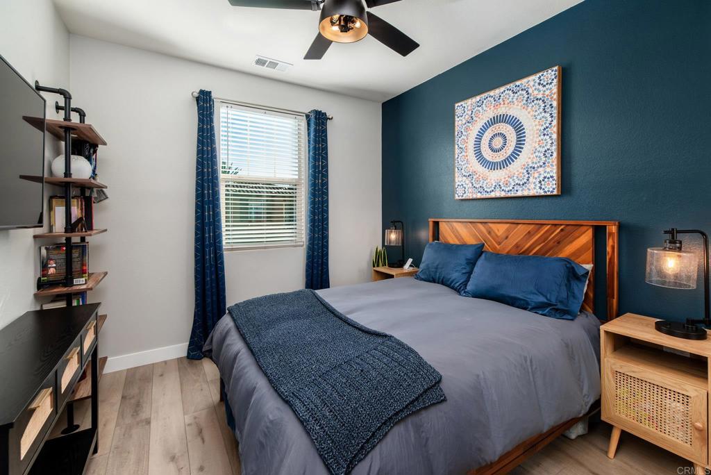 1244 Via Candelas Oceanside, CA 92056 - Photo 37 of 60 a bedroom with a bed and a chandelier