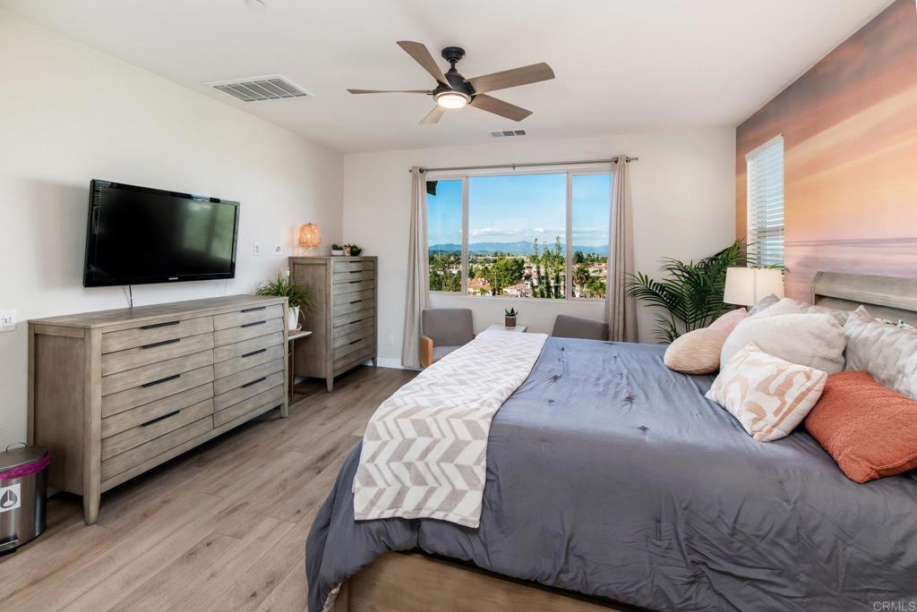 1244 Via Candelas Oceanside, CA 92056 - Photo 45 of 60 a bedroom with a bed a flat screen tv and a couch