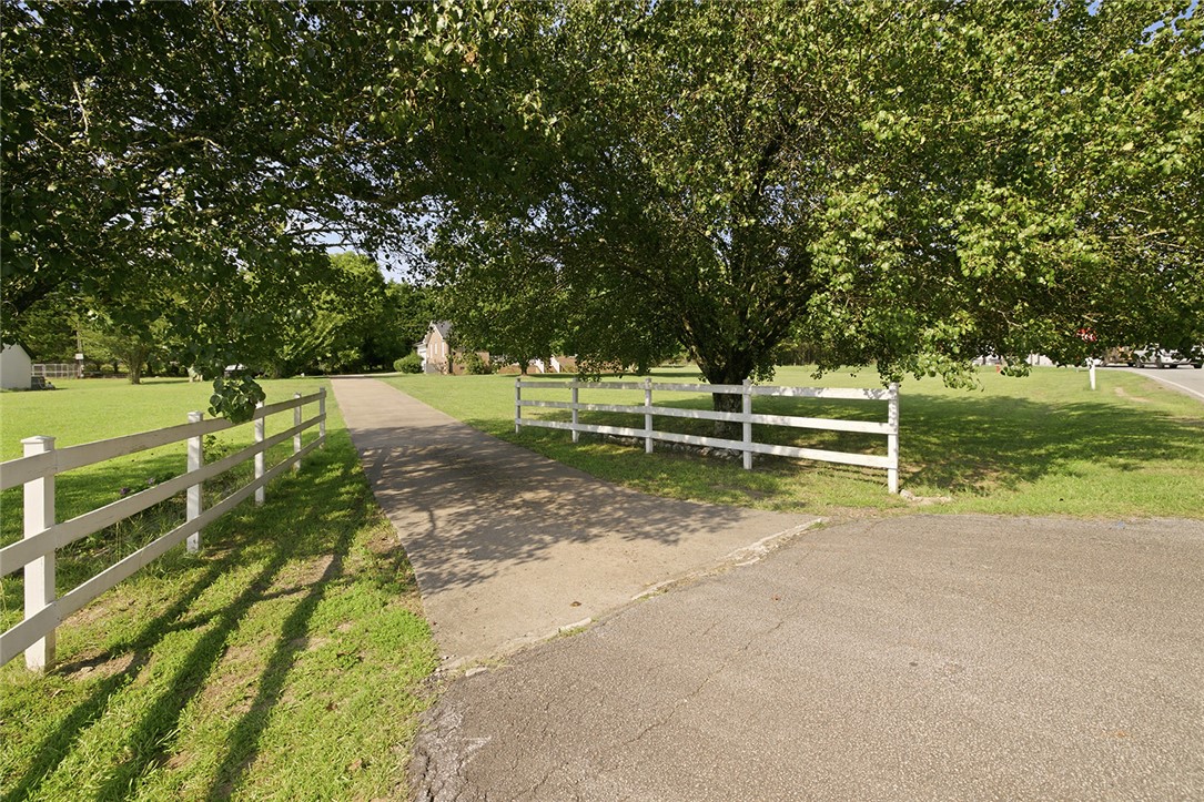 902 Cherokee Road Pelzer, SC 29669 - Photo 31 of 38 A graceful white fence borders the long private driveway, leading to the inviting residence.