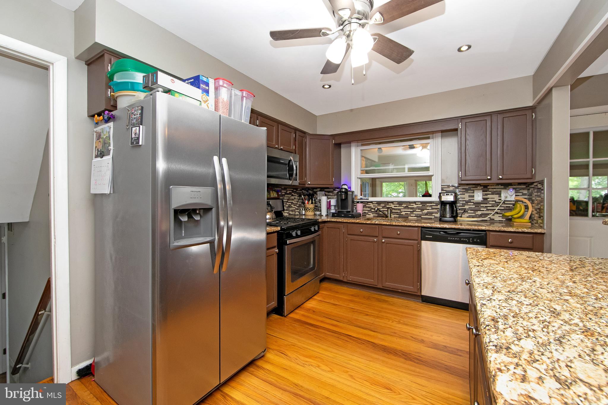 421 Yorkshire Road Cherry Hill, NJ 08034 - Photo 12 of 38 a kitchen with stainless steel appliances granite countertop a refrigerator a sink a stove a microwave oven with a dining table and chairs