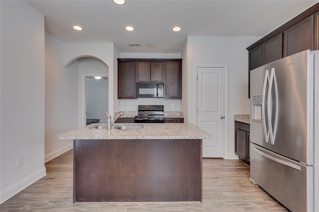 141 Capslock Trail Pendleton, SC 29670 - Photo 20 of 38 A well-appointed kitchen features dark wood cabinetry, granite countertops, and modern stainless steel appliances.