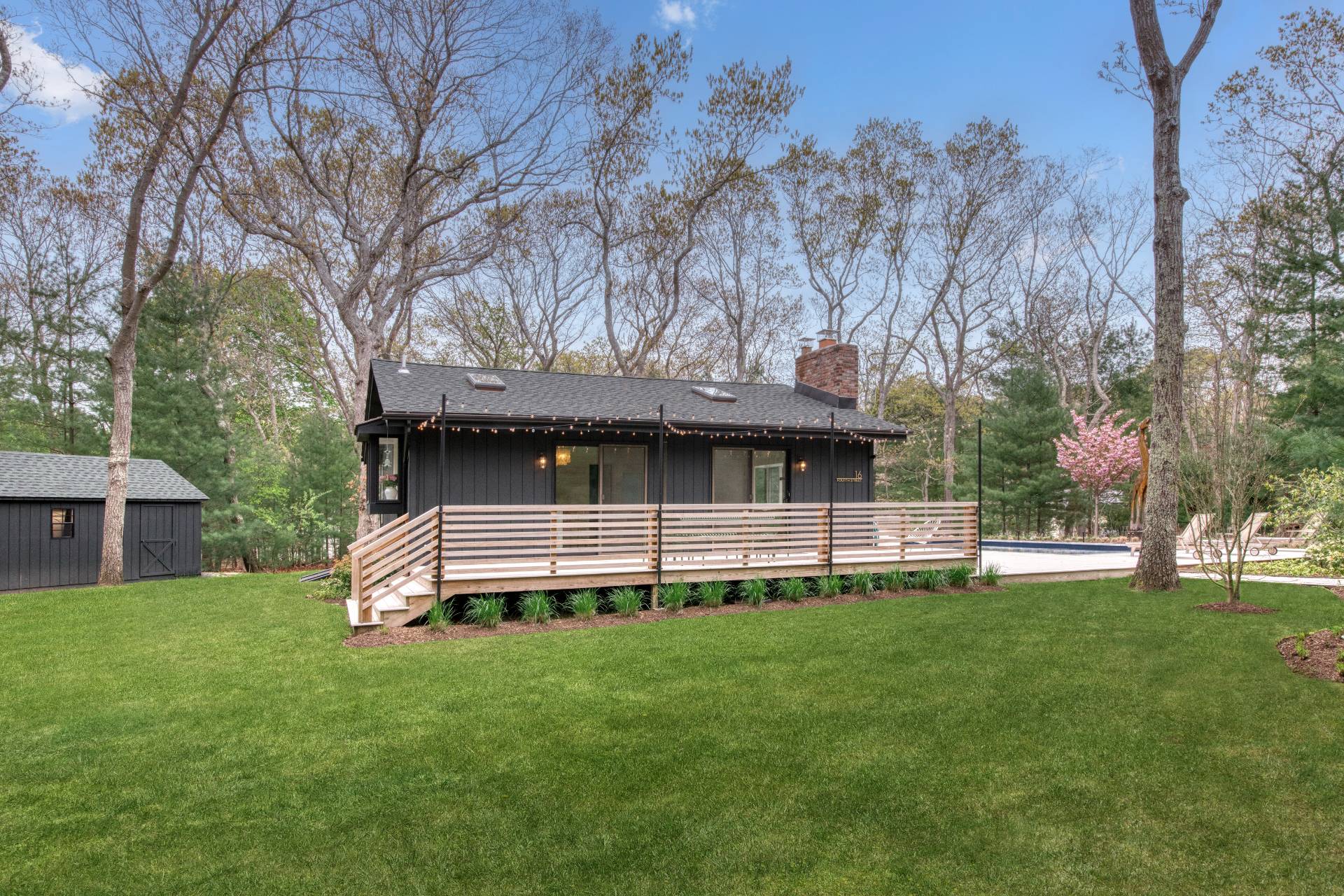 16 4th Street East Hampton, NY 11937 - Photo 13 of 18 a front view of a house with a garden and tree