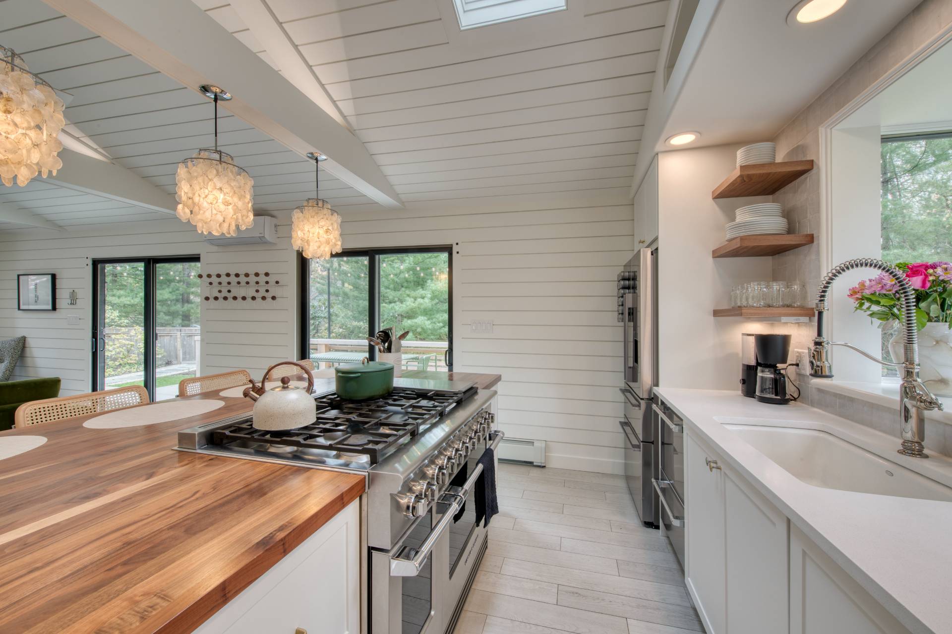 16 4th Street East Hampton, NY 11937 - Photo 6 of 18 a kitchen with a stove a sink a chandelier and living room view