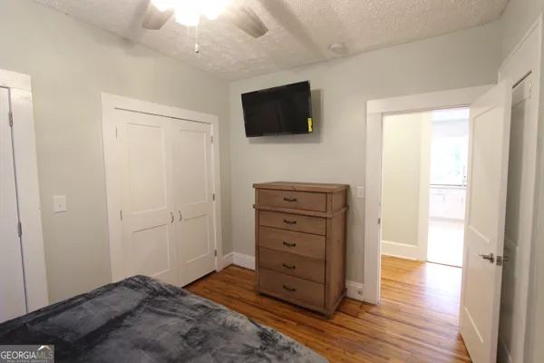 a view of bedroom with wooden floor and flat screen tv