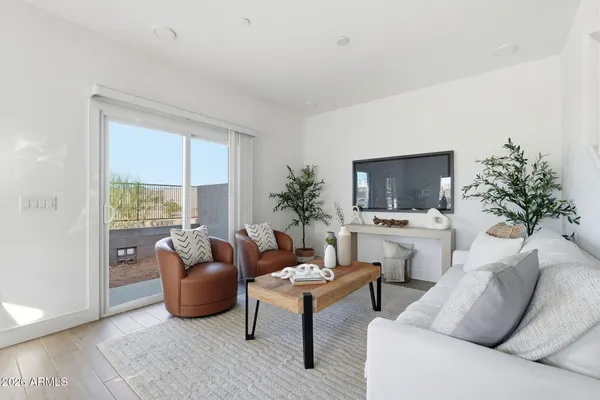 a living room with furniture a flat screen tv and a large window