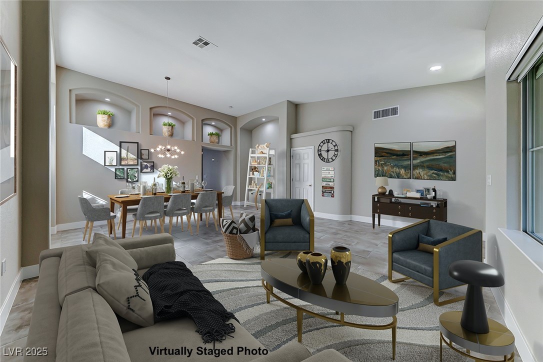 Living area featuring a chandelier, built in shelves, and recessed lighting