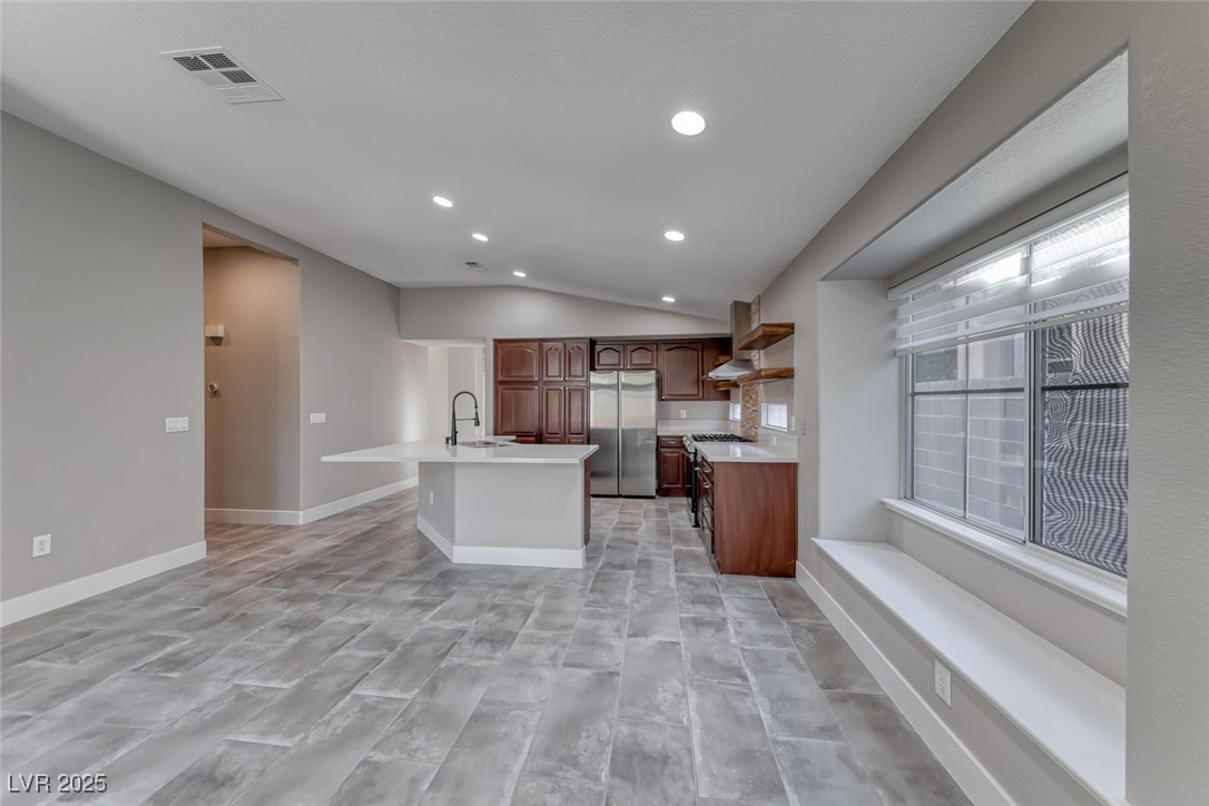 2401 Flower Spring Street Las Vegas, NV 89134 - Photo 15 of 42 Kitchen with freestanding refrigerator, a kitchen island with sink, lofted ceiling, recessed lighting, and light wood-type flooring