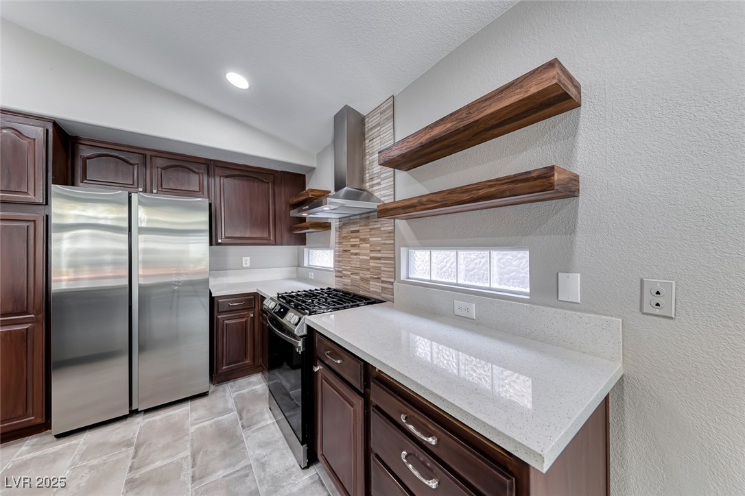 2401 Flower Spring Street Las Vegas, NV 89134 - Photo 20 of 42 Kitchen featuring open shelves, appliances with stainless steel finishes, dark brown cabinetry, vaulted ceiling, and a textured wall