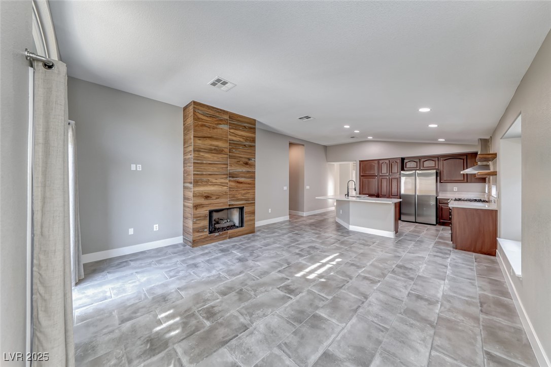 2401 Flower Spring Street Las Vegas, NV 89134 - Photo 22 of 42 Unfurnished living room featuring a fireplace, recessed lighting, and lofted ceiling