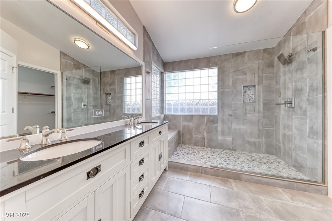 2401 Flower Spring Street Las Vegas, NV 89134 - Photo 27 of 42 Full bath with a walk in closet, a stall shower, double vanity, and light tile patterned floors
