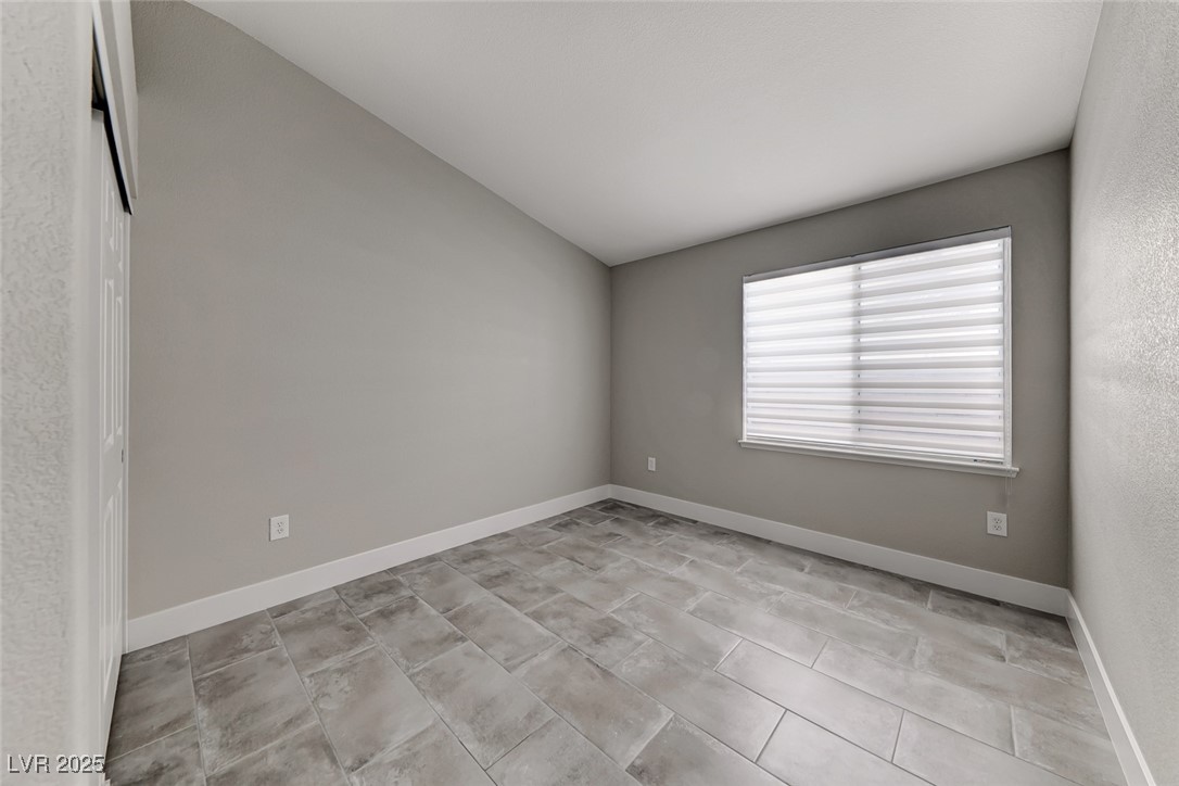 2401 Flower Spring Street Las Vegas, NV 89134 - Photo 32 of 42 Unfurnished room with lofted ceiling and light tile patterned floors